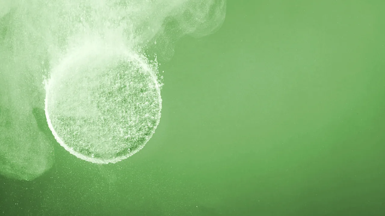 A OneTab cleaning tablet dissolving and fizzing in water